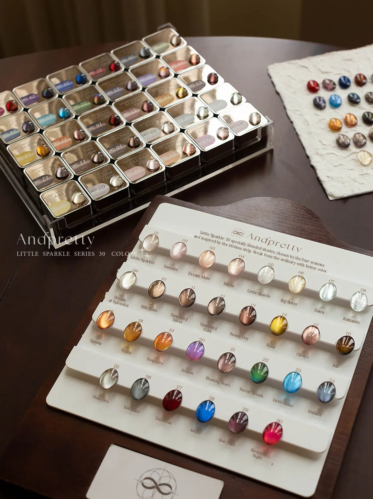 Andpretty Little Sparkle cat eye gel: 30-shade swatch board with shade names, beside the jar tray