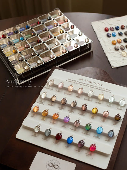 Andpretty Little Sparkle cat eye gel: 30-shade swatch board with shade names, beside the jar tray