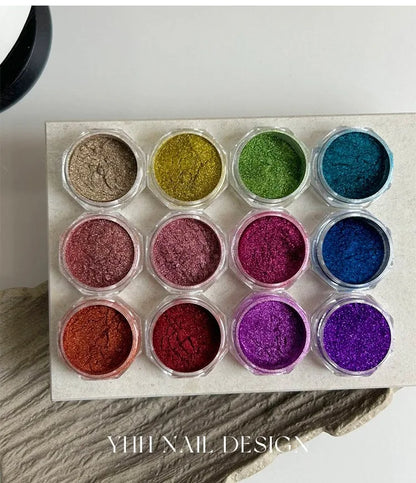 Twelve open jars of colored chrome powder