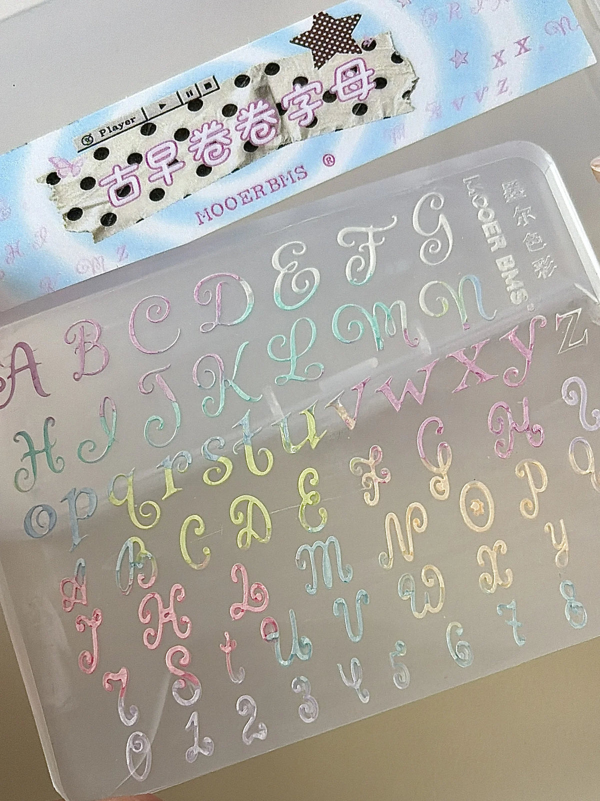 Close-up of pastel curly letter charms in the mold