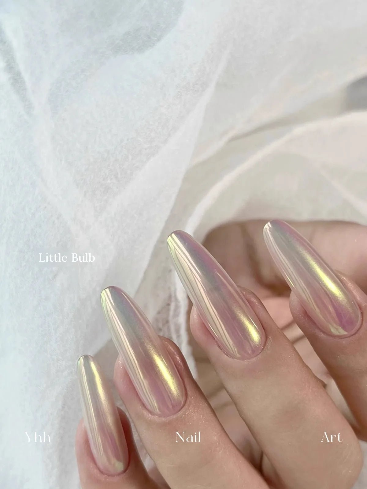 Little Bulb silk chrome powder worn on long almond nails over a sheer neutral base