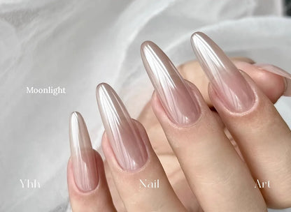 Moonlight silk chrome powder worn on long almond nails over a sheer neutral base