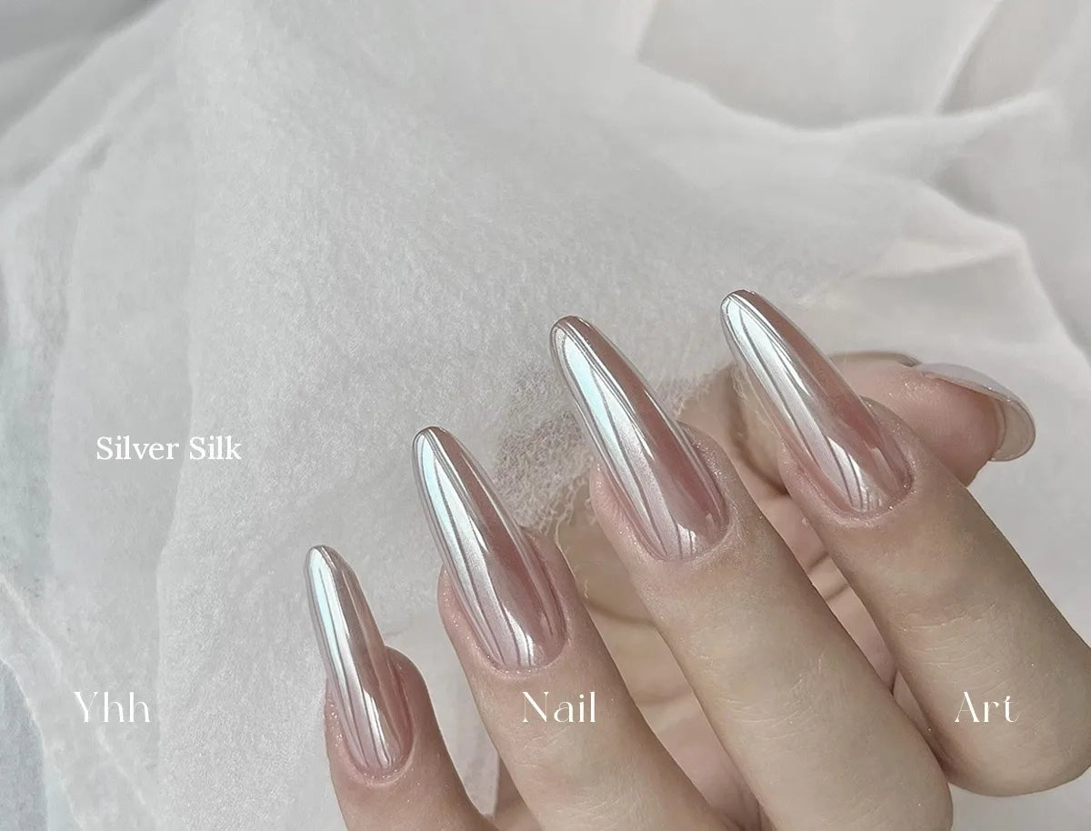 Silver Silk silk chrome powder worn on long almond nails over a sheer neutral base