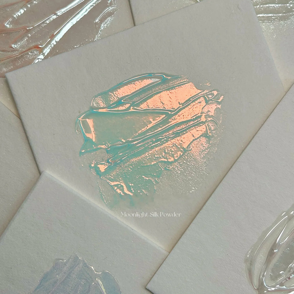 Silk powder rubbed over clear gel showing a peach-to-aqua aurora sheen