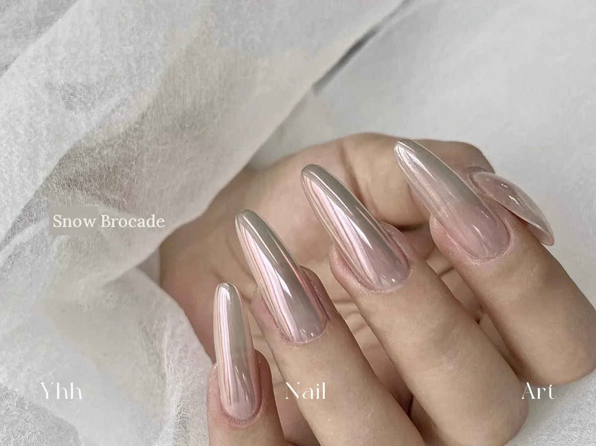 Snow Brocade silk chrome powder worn on long almond nails over a sheer neutral base