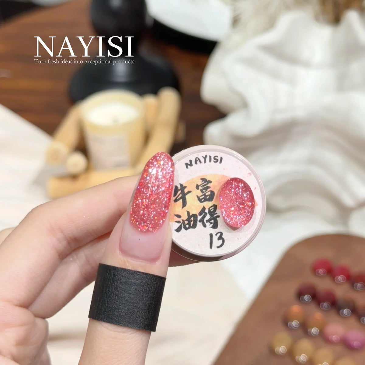 Riches and Treasures 3.0 13, salmon pink glitter, on a nail beside its jar
