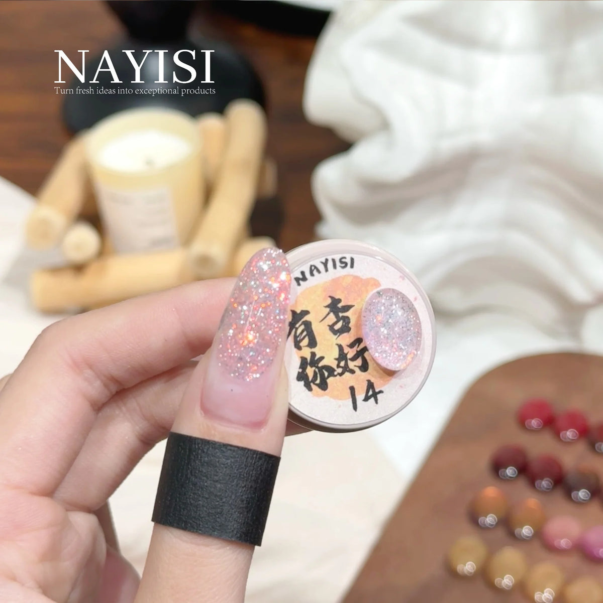 Riches and Treasures 3.0 14, soft blush glitter, on a nail beside its jar