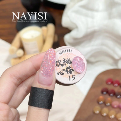Riches and Treasures 3.0 15, sheer baby pink glitter, on a nail beside its jar