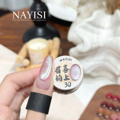 Riches and Treasures 3.0 30, milky pearl cat eye with aurora shimmer, on a nail beside its jar
