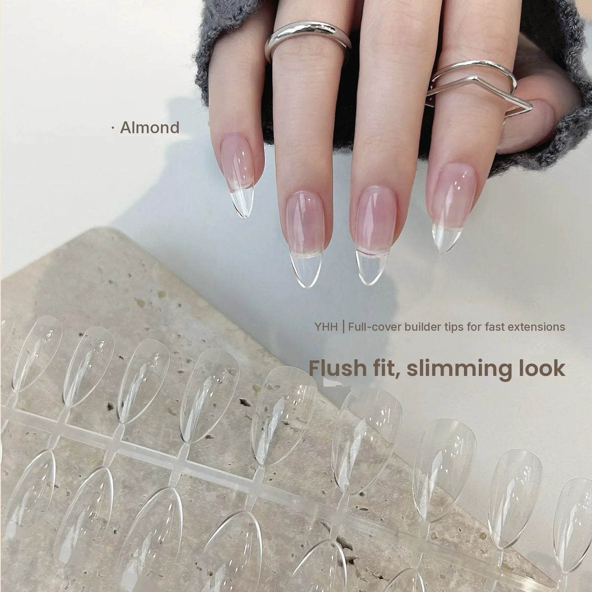 Hand wearing YHH clear almond full-cover tips over a pink base