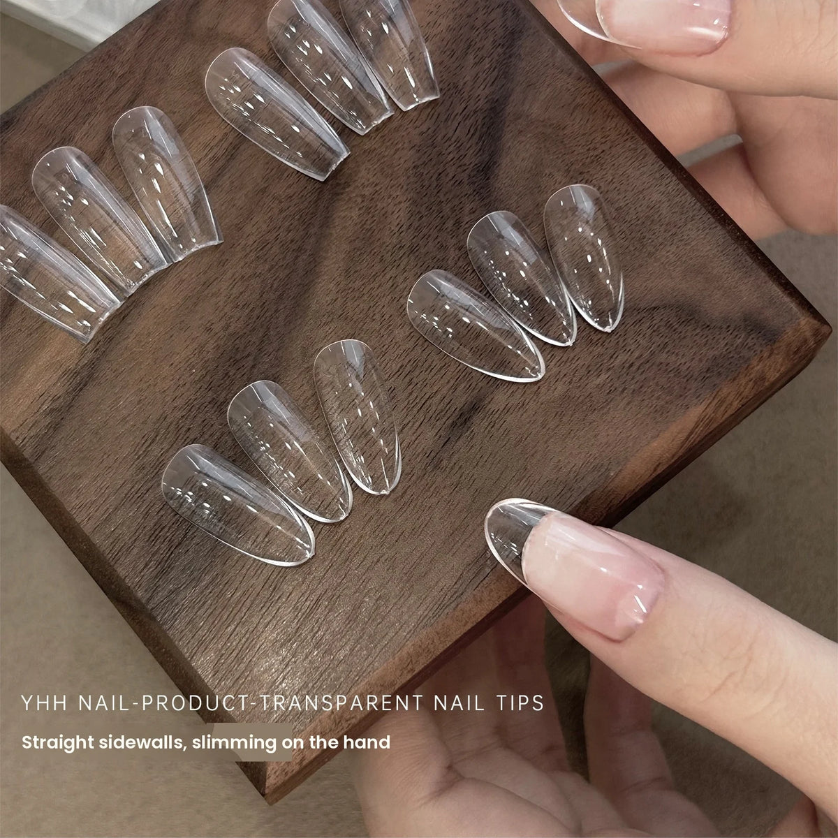 Hand holding a dark wooden block with clear YHH full-cover tips