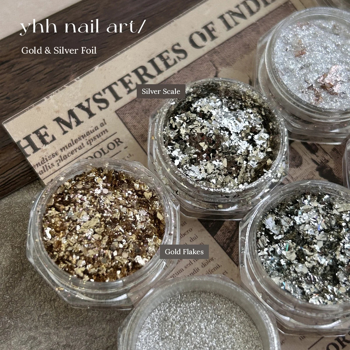 Jars of YHH gold and silver foil flakes on newsprint