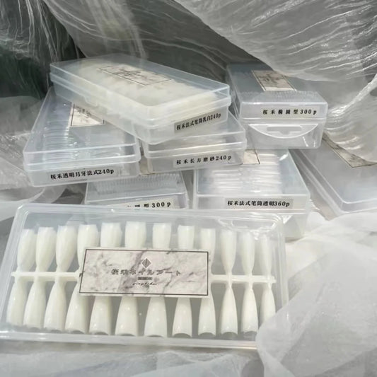 Stack of YHH nail tip boxes in crescent French, tube French, oval and squoval styles