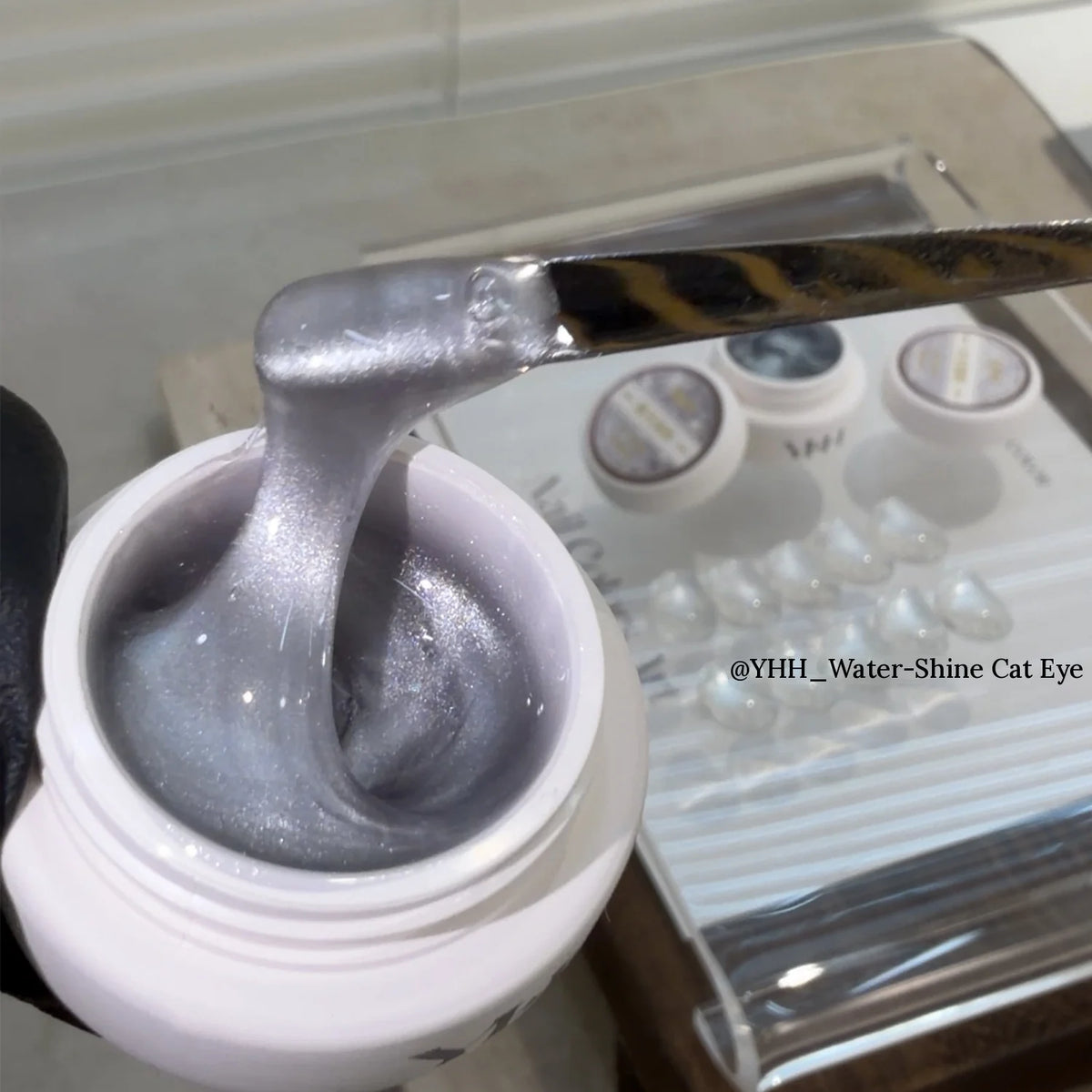 YHH Water-Shine sheer cat eye gel on a spatula over the jar